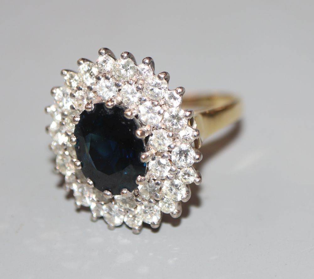 A modern 18ct gold, sapphire and diamond set oval cluster ring, size L, gross 7 grams.